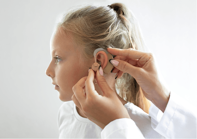 Girl adjusting an in-ear wearable device